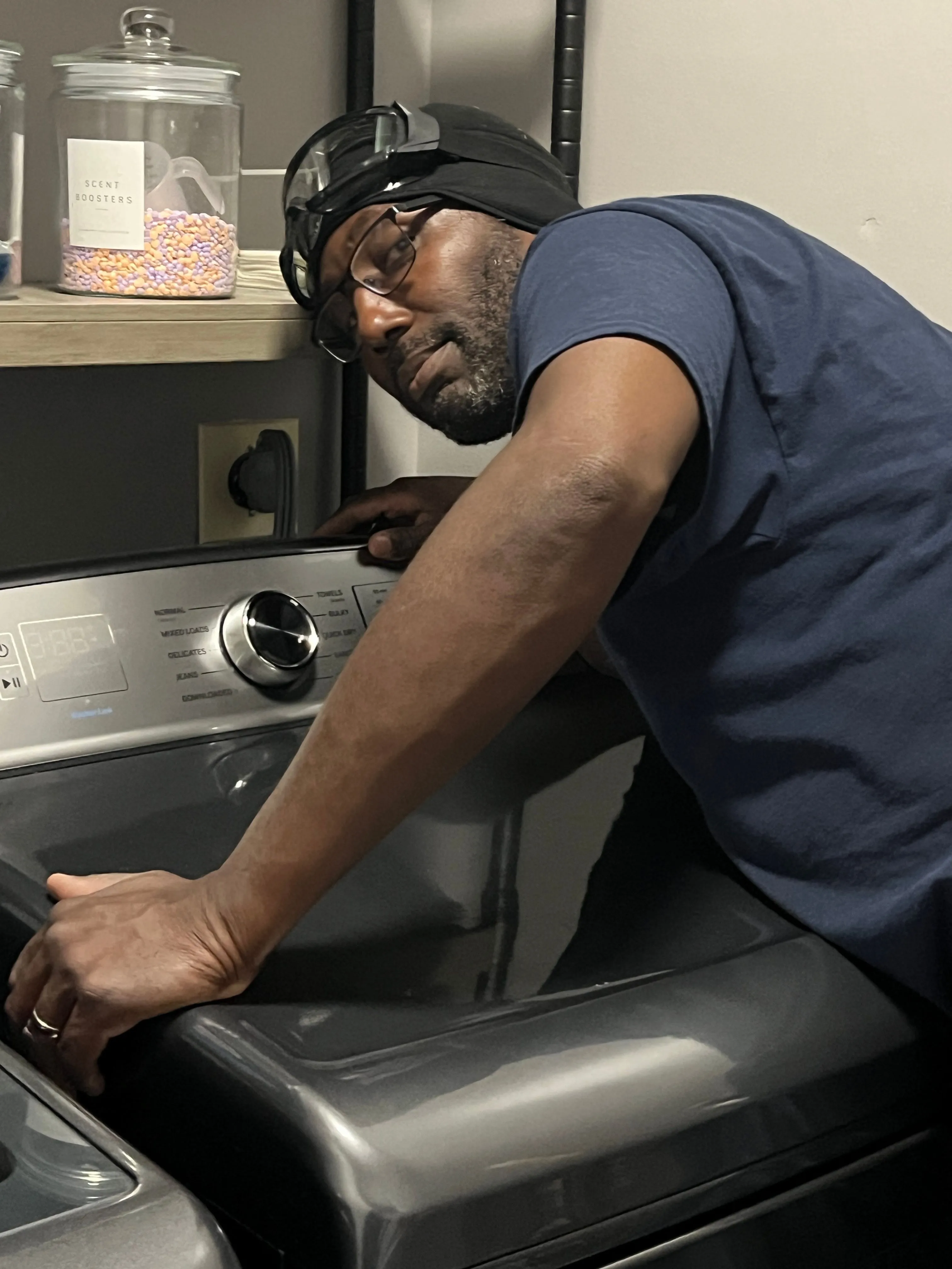 Kester, owner of Bowie Dryer Vent Cleaning, working on a dryer's exterior vent connection.
